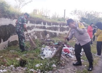 Bhabinkamtibmas AIPTU Alexander dan AIPTU Wellinton Nababan mengikuti kegiatan gotong royong bersama di Jalan Jintar Saragih