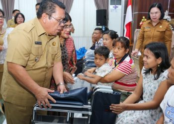 Wali Kota Wesly Silalahi SH MKn didampingi Ketua TP PKK Ny Liswati Wesly Silalahi menyerahkan kursi roda kepada penyandang disabilitas.