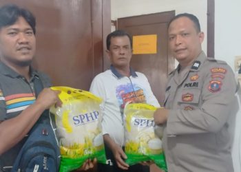 Personil Polseķ Sianțar Selatan saat memberikan beras SPHP yang dibeli masyarakat