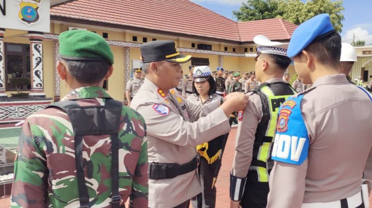 Kapolres Simalungun AKBP Marganda Aritonang, S.H. S.I.K. M.M sematkan tanda pita Operasi Lilin Toba 2025 kepada perwakilan personil