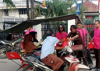 Kajari Tanjungbalai Bobon Robiana SH. MH saat berikan bingkisan kepada abang becak