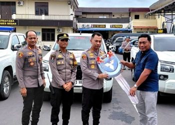 Wakil Bupati (Wabup) Deli Serdang, Lom Lom Suwondo SS saat menyerahkan bantuan 3 unit mobil operasional kepada Polrestabes Medan yang diterima Kapolrestabes Medan, Kombes Pol Dr Jean Calvijn Simanjuntak. (Foto Ist)