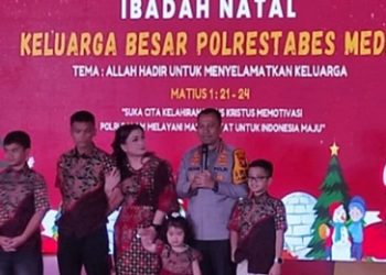 Kapolrestabes Medan Kombes Pol Dr. Jean Calvijn Simanjuntak, S.I.K., M.H didampinggi Ketua Bhayangkari Cabang Kota Besar Medan Ny. Nelly Calvijn Simanjuntak saat prosesi penyalaan lilin dalam perayaan Natal Keluarga Besar Polrestabes Medan. (Foto Ist)
