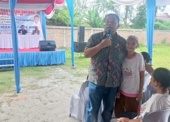 Anggota DPRD Kota Medan, Binsar Simarmata saat pelaksanaan Sosialisasi Perda (Sosper) ke II Tahun 2026 produk hukum Pemko Medan Perda Nomor 3 tahun 2021 tentang Penyelenggaraan Administrasi Kependudukan Kota Medan yang saat itu membantu langsung seorang ibu yang tidak memiliki KTP. (Foto Ist)