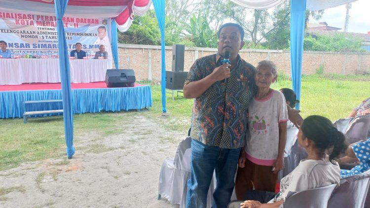 Anggota DPRD Kota Medan, Binsar Simarmata saat pelaksanaan Sosialisasi Perda (Sosper) ke II Tahun 2026 produk hukum Pemko Medan Perda Nomor 3 tahun 2021 tentang Penyelenggaraan Administrasi Kependudukan Kota Medan yang saat itu membantu langsung seorang ibu yang tidak memiliki KTP. (Foto Ist)