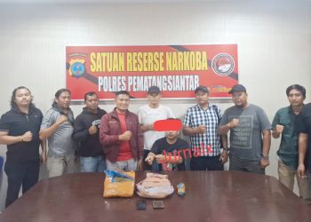Tersangka DS dan barang bukti diapit KBO Sat Narkoba IPTU Apri Damanik SH. MH bersama Kanit 1 IPDA Warman Siallagan, Tim Opsnal dan Tim Intel Kodim 022/PT di ruangan Sat Resnarkoba Polres Pematangsiantar