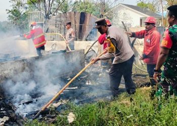 Personil Polsek Serbalawan bersama Petugas Damkar saat padamkan kobaran api