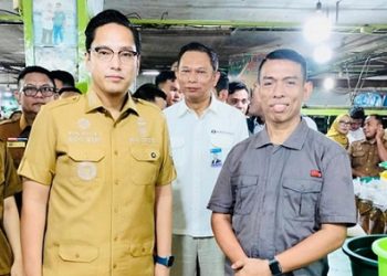 Wali Kota Medan, Rico Tri Putra Bayu Waas berfoto bersama Suwarno salah satu pedagang usai meninjau Pasar Petisah untuk memastikan stabilitas harga dan ketersediaan bahan pokok. (Foto Ist)