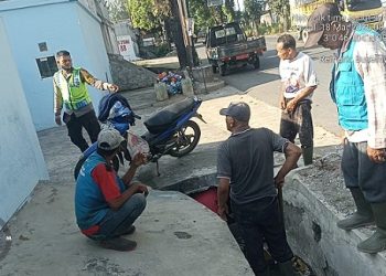 Bhabinkamtibmas Kelurahan Tambun Nabolon AIPTU Jonson Hutahuruk melaksanakan monitoring pemberishan parit di Jalan Medan KM 8