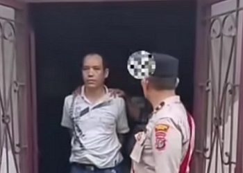 Pelaku Jefri Fernandus Sitindaon alias JFS (41) yang menikam tetangganya saat diamankan polisi. (Foto Ist)