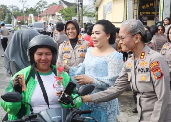 Kapolres Pematangsianțar AKBP Sah Udur T.M Sitinjak S.H. S.I.K. M.H saat berikan bunga dan coklat kepada perempuan pengendara sepedamotor