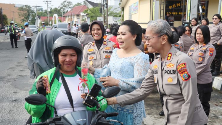 Kapolres Pematangsianțar AKBP Sah Udur T.M Sitinjak S.H. S.I.K. M.H saat berikan bunga dan coklat kepada perempuan pengendara sepedamotor