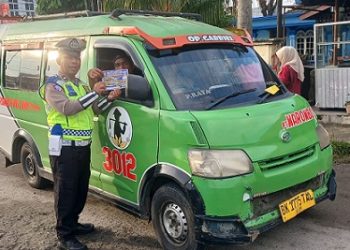 Kanit Kamsel IPDA Serly Tarigan bersama personil melaksanakan pembagian brosur tertib berlalu lintas kepada masyarakat pengguna jalan