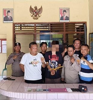 Tersangka IKS dan barang bukti diapit Kanit Reskrim IPDA B. Situngkir SH bersama Tim Opsnal saat di Polsek Gunung Malela