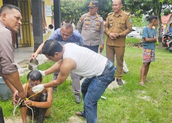 Kapolsek Gunung Malela AKP Hengky B. Siahaan, S.H. M.H bersama personil mandikan Pelaku penggali kuburan diduga ODGJ
