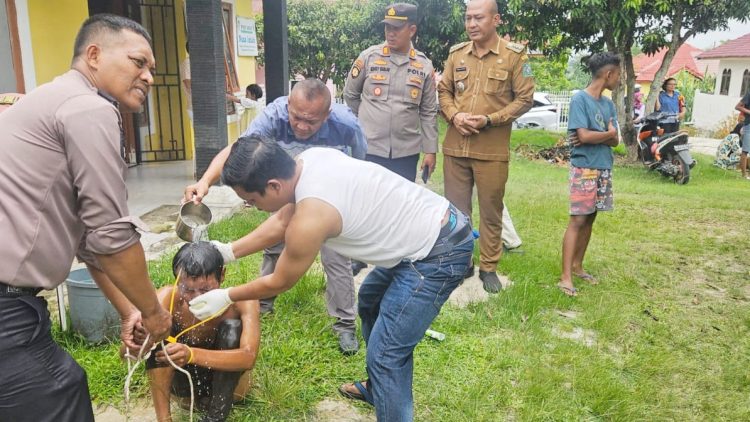 Kapolsek Gunung Malela AKP Hengky B. Siahaan, S.H. M.H bersama personil mandikan Pelaku penggali kuburan diduga ODGJ