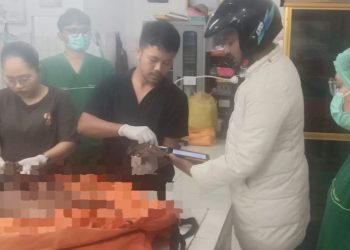 Inafis Polres Simalungun Aiptu Sujid Syahputra dibantu Tim Inafis saat sidik jari mayat Mr X untuk mencari identitasnya diruangan jenajah RSUD dr Djasamen Saragih Kota Pematangsiantar