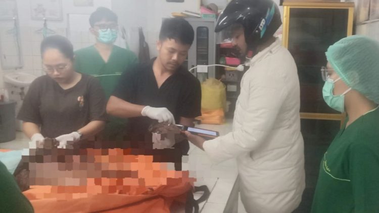 Inafis Polres Simalungun Aiptu Sujid Syahputra dibantu Tim Inafis saat sidik jari mayat Mr X untuk mencari identitasnya diruangan jenajah RSUD dr Djasamen Saragih Kota Pematangsiantar