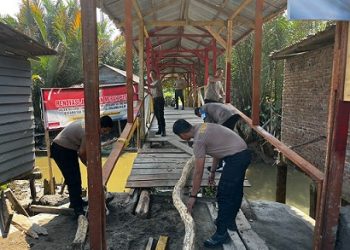 Personel Polsek Teluk Nibung Renovasi Jembatan Merah Putih