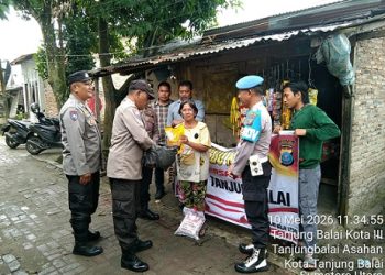 Ps. Kabagops Polres Tanjung Balai, AKP Natal Fernando Saragih, S.Pd saat berikan bansos kepada Ibu Rumandang Meilida br. Napitupulu