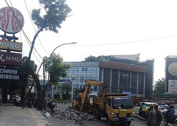 Personil Satpol PP Kota Medan membongkar trotoar dan jalur pedestrian yang dicaplok J.CO Donuts & Coffee, Jalan H Adam Malik, Kecamatan Medan Barat untuk area parkir. (Foto Ist)