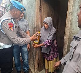 Kasi Propam AKP Hotben Pasaribu didampingi Kanit Reskrim Polsek Teluk Nibung Ipda Elwin A. Hutagaol, S.H serta sejumlah personel gabungan saat berikan sebako kepada Wak Imah