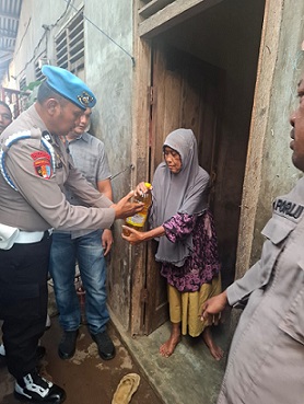 Kasi Propam AKP Hotben Pasaribu didampingi Kanit Reskrim Polsek Teluk Nibung Ipda Elwin A. Hutagaol, S.H serta sejumlah personel gabungan saat berikan sebako kepada Wak Imah