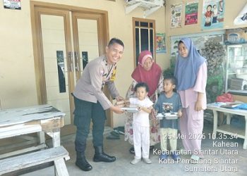 Bhabinkamtibmas Kelurahan Kahean Polsek AIPDA H.E. Pane saat serahkan MBG kepada Balita