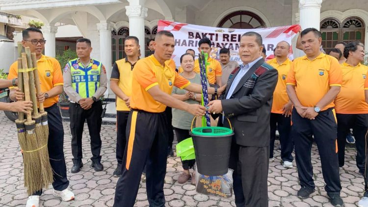 Kasat Samapta AKP Mariduk Tambunan, S.H. M.H mewakili Kapolres Pematangsiantar saat berlaku peralatan kebersihan kepada Pengurus Gereja HKI Jalan Melanthon Siregar