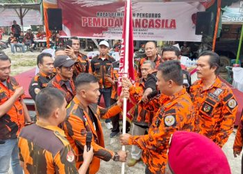 Ketua PAC PP Kecamatan Sianțar Barat Terpilih Andika Prayogi Sinaga SE saat menerima pataka bendera Organisasi PP dari Ketua Ketua MPC PP Kota Pematangsiantar Ronald Darwin Tampubolon