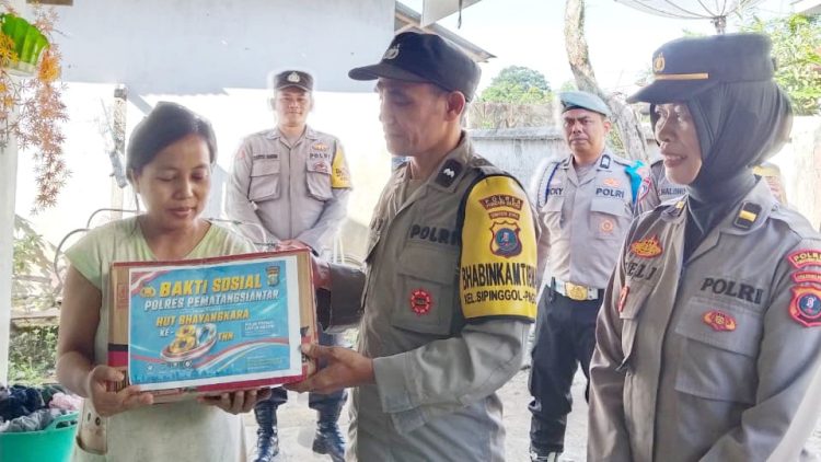 Kapolsek Sianțar Barat IPTU Raja Kaya Haloho SH. MH didampingi Kanit Binmas IPDA Meli dan personil saat berikan bansos kepada Siti Handayani