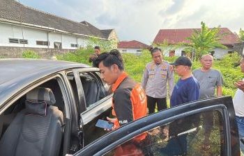 Kapolsek Medan Area, AKP M Ainul Yaqin di TKP bersama mobil pasutri yang meninggal setelah kaca mobil dipecahkan. (Foto Ist)