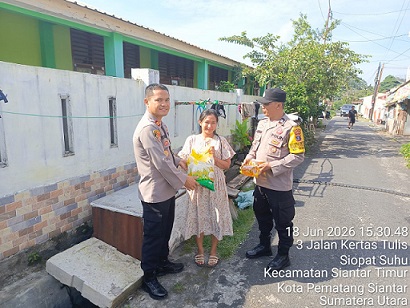 Kapolsek Siantar Timur IPTU Edy J.J. Manalu SH. MH didampingi Bhabinkamtibmas saat berikan bansos kepada warga kurang mampu