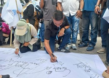Ketua DPC Macan Asia Indonesia saat menadatangani petisi untuk mendumung Makan Bergizi Gratis. (Foto Ist)