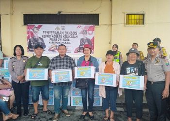Wakapolres KOMPOL Budiono Saputro S.H., M.H didampingi Kapolsek Siantar Utara AKP Jahrona Sinaga S.H saat berikan bansos secara simbolis kepada perwakilan korban kebakaran kios Pasar Dwikora