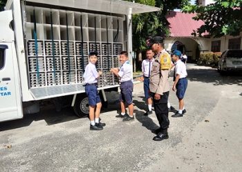 Bhabinkamtibmas Kelurahan Pardomuan Aipda Hardi N. Silalahi melaksanakan pendistribusian Makanan Bergizi Gratis (MBG) di UPTD SMP Negeri 1