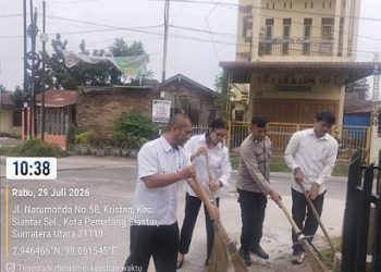 Bhabinkamtibmas Kelurahan Kristen Bripka Swandi mengikuti kegiatan gotong royong di jalan Laguboti