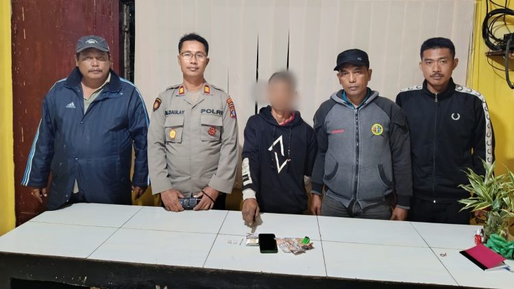 Pelaku NT alias Karnas dan barang bukti diapit Kapolsek Dolok Silau M. Nasir Daulay, SH dan personil