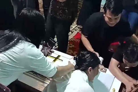 Yestin Laia ibunda dari Winda Lorenza Gowasa memeluk erat peti jenazah saat dilakukan proses pemakaman. (Foto Romulo Sinaga/jurnalx.co.id)