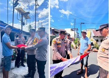 Plh. Kapolsek Siantar Selatan IPDA Jaya Manihuruk SH bersama personil saat bagikan bendera Merah Putih kepada warga