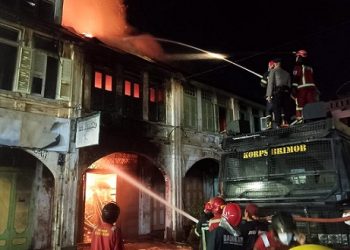 Personil Sat Brimob menggunkan mobil AWC saat berusaha padamkan kobaran api yang membakar ruko