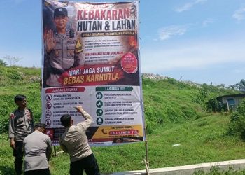 Kanit Binmas IPDA Nirwan Sirait bersama Bhabinkamtibmas AIPTU S. Ambarita, AIPTU Jonson Hutauruk dan AIPDA Nurdiansyah melakukan pemasangan spanduk waspada Karhutla di Jalan Rondahaim Saragih
