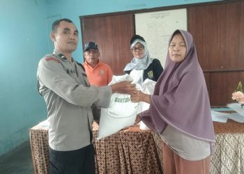 Bhabinkamtibmas Aipda Saut M Manurung monitoring distribusi Banpang beras kepada warga Kelurahan Sipinggol Pinggol