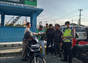 Personil Unit Kamsel membagikan brosur Tertib Berlalulintas Kepada Pengemudi ojek online (Ojol) di Jalan Parapat