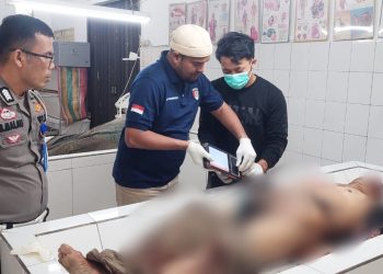 Tim Inafis AIPDA Sujid Sahputra saat pencarian identitas korban diruangan jenajah RSUD dr Djasemen Saragih