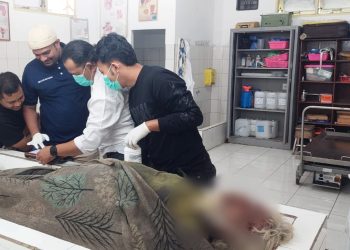 Tim Inafis AIPDA Sujid Saputra saat pencarian identitas korban diruangan jenajah RSUD dr Djasamen Saragih Kota Pematangsiantar