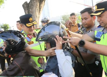 Kapolda Irjen Pol. Sonny Irawan, S.I.K., M.H dan Kapolrestabes Medan Kombes Pol Dr. Jean Calvijn Simanjuntak saat mengenakan helm kepada masyarakat terkait tertib lalu lintas
di Jalan Lapangan Merdeka, Medan (Foto Ist)