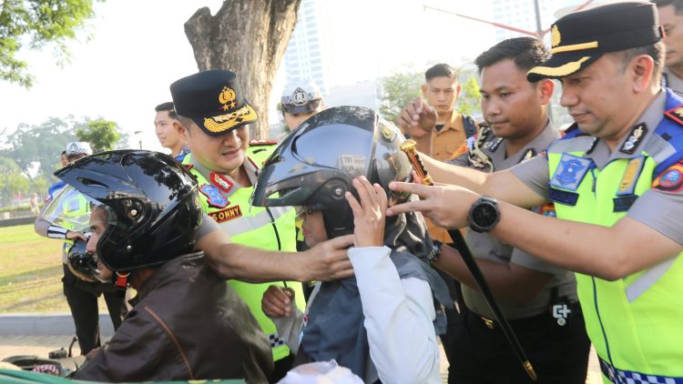 Kapolda Irjen Pol. Sonny Irawan, S.I.K., M.H dan Kapolrestabes Medan Kombes Pol Dr. Jean Calvijn Simanjuntak saat mengenakan helm kepada masyarakat terkait tertib lalu lintas
di Jalan Lapangan Merdeka, Medan (Foto Ist)