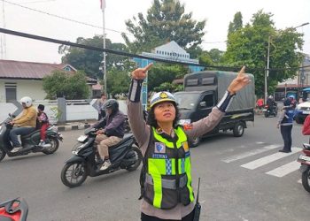 Kanit Kamsel IPDA Serly Tarigan saat cek kabel listrik yang semrawut dan menjuntai hingga mendekati trotoar di Jalan Kartini