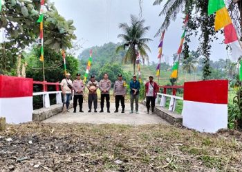 Kapolsek Siantar Martoba IPTU Edy J.J. Manalu SH. MH bersama personil melakukan renovasi atau perbaikan jembatan Merah Putih di Kelurahan Naga Pita